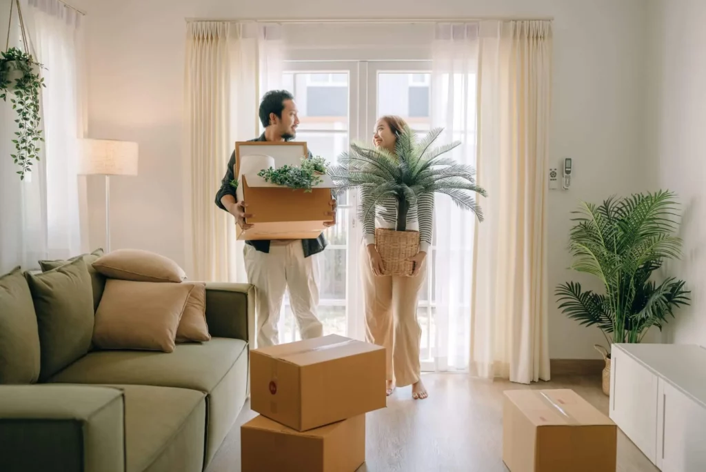 Imagem de um casal dentro de uma casa segurando algumas caixas de papelão para ilustrar matéria sobre a declaração de imposto de renda 2024
