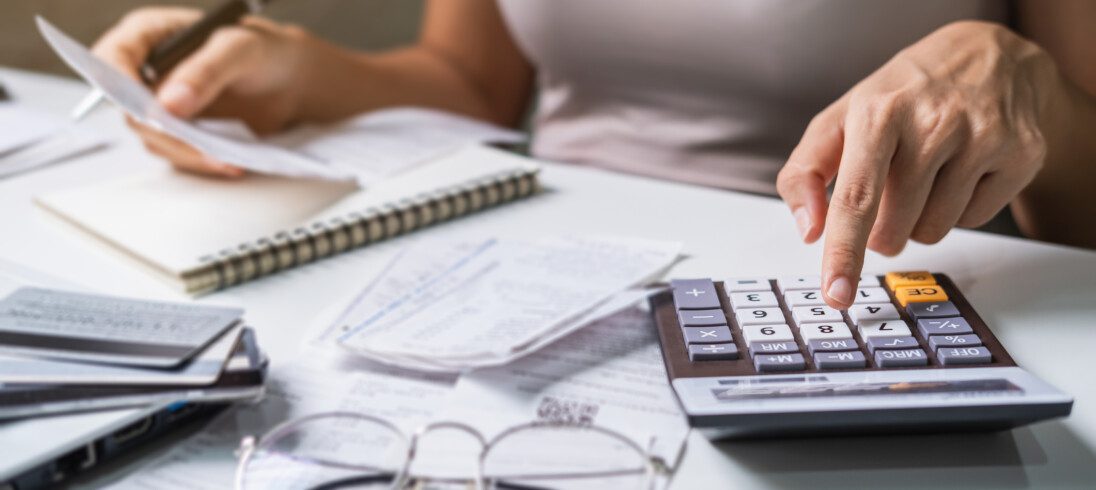 Foto que ilustra matéria sobre preço de aluguel, mostra as mãos de uma mulher em detalhe enquanto ela usa um calculadora.