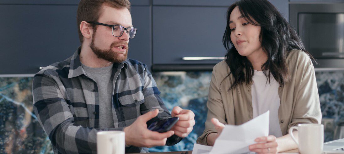 Homem e uma mulher realização uma negociação na mesa de um café. Imagem disponível em Pexels.