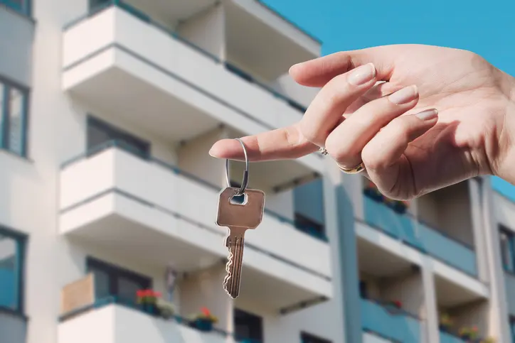 Foto de uma pessoa segurando uma chave de apartamento.