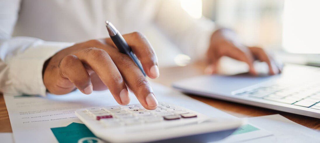 Um homem calcula, com auxílio da calculadora, a multa pela rescisão de um contrato de aluguel.