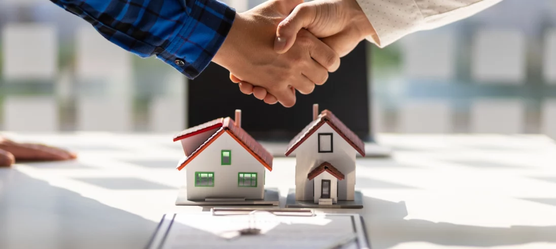 Imagem de duas pessoas apertando as mãos após a assinatura de um contrato imobiliário bem sucedido para ilustrar matéria de como sair do aluguel