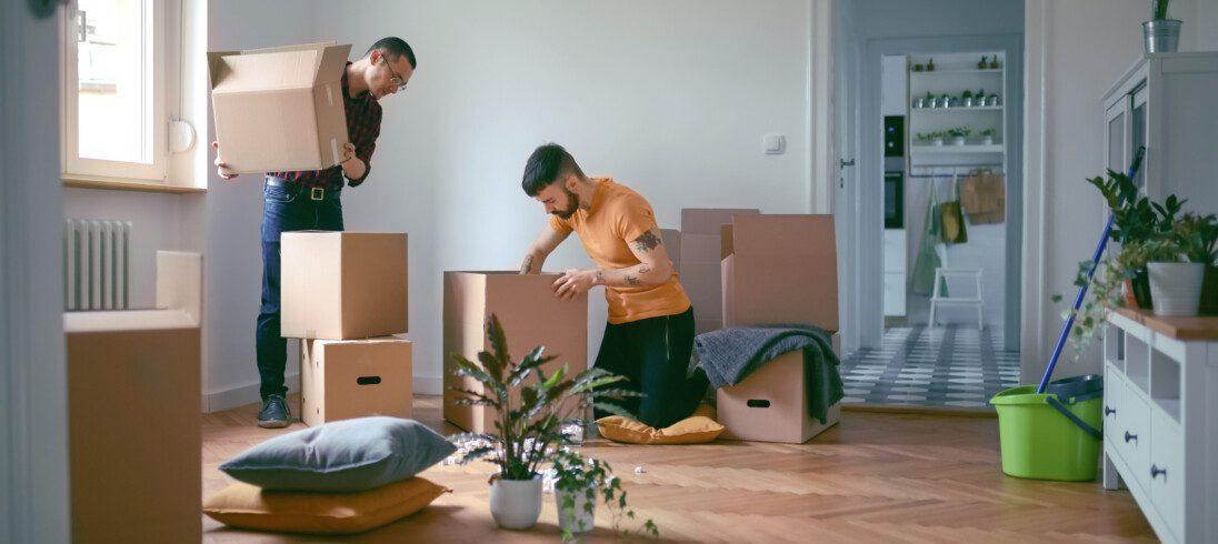 Imagem de dois homens empacotando objetos da casa em caixas para ilustrar matéria sobre o prazo para desocupação de imóvel