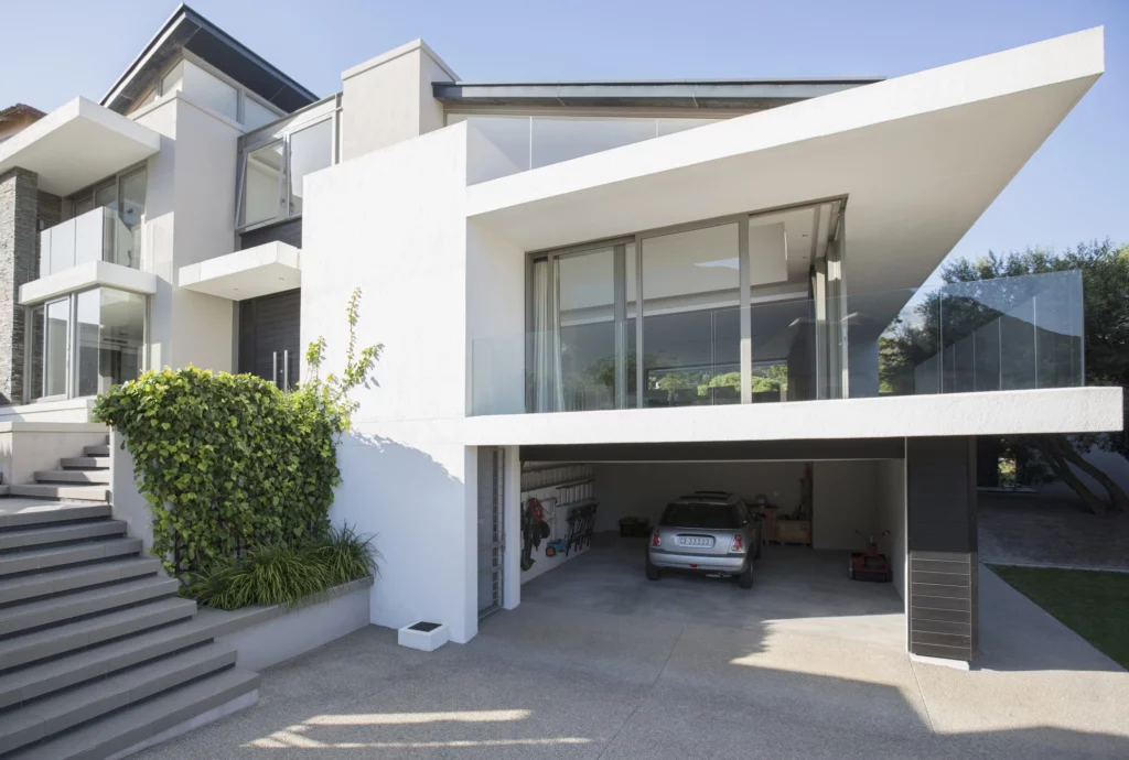 Imagem de uma casa moderna com estacionamento abaixo do nível da rua para ilustrar matéria sobre garagem subterrânea: vantagens e desvantagens