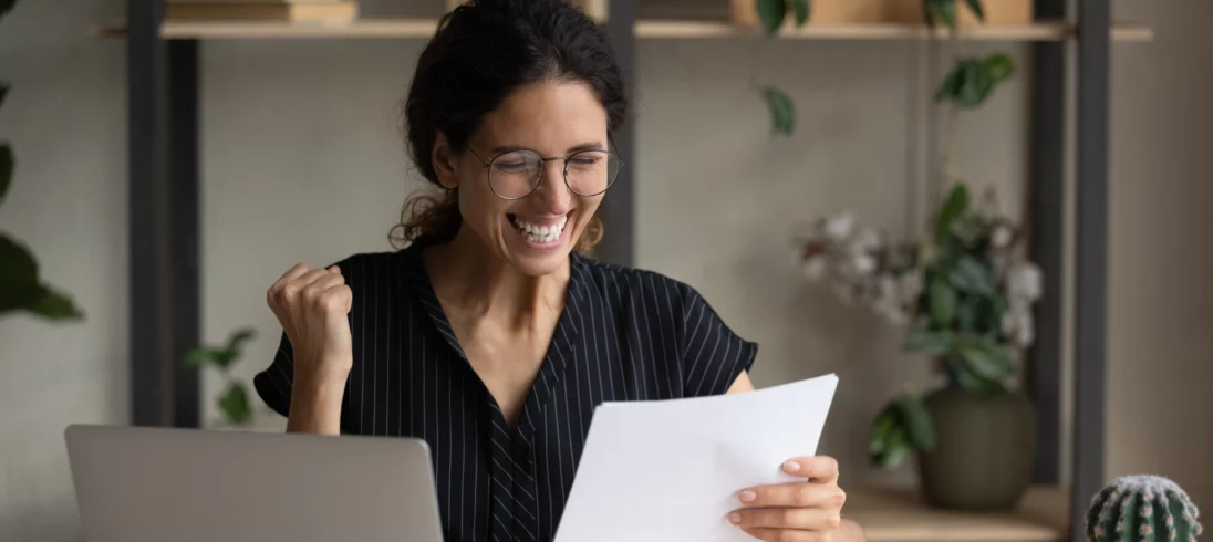 Imagem de uma mulher recebendo uma notícia boa em um contrato para ilustrar matéria sobre: "fui contemplado no consórcio, preciso comprovar renda?"