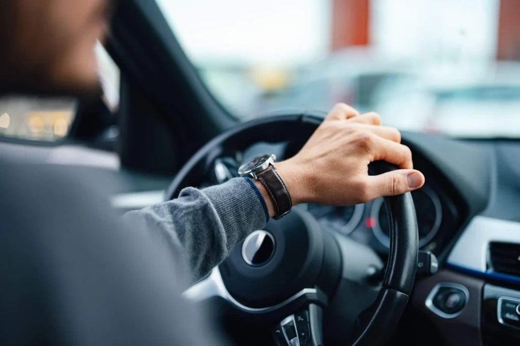 Imagem de um homem com a mão no volante dirigindo um carro para ilustrar matéria sobre garagem de condomínio é área comum
