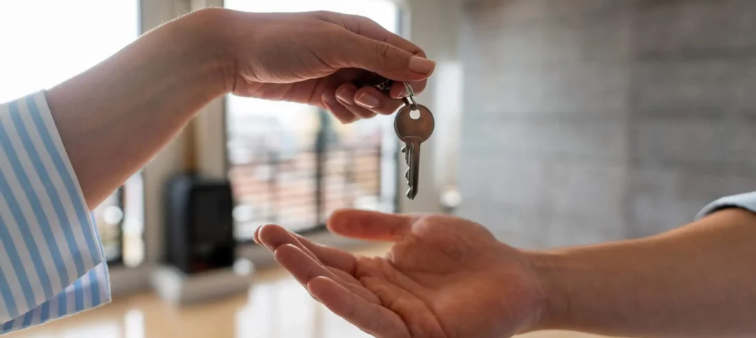 Imagem de uma mulher entregando as chaves de um apartamento para um homem para ilustrar a matéria sobre seguro fiança é devolvido