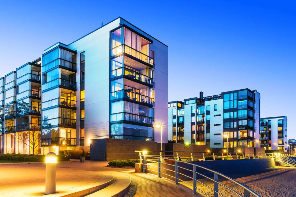 Imagem de condominio residencial de prédios de seis andares moderno durante o início da noite para ilustrar matéria sobre o que condomínio inteligente 
