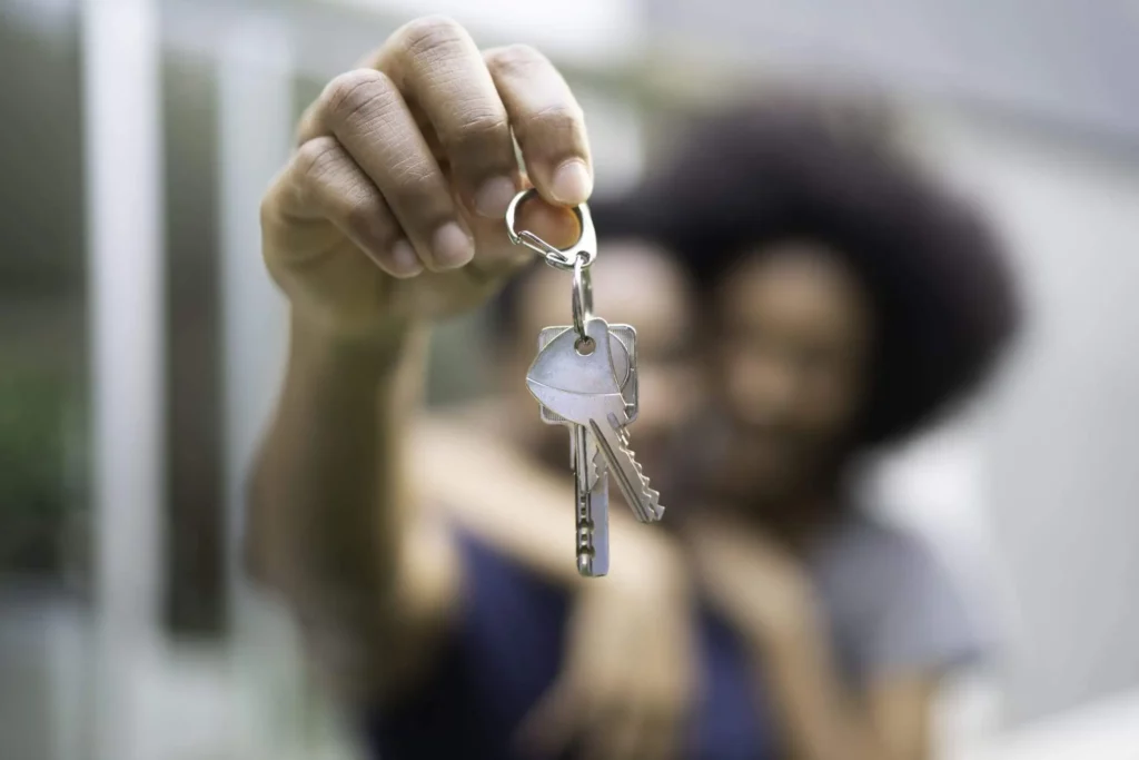 Imagem de um homem e uma mulher segurando a chave de um imóvel para ilustrar matéria sobre como saber o valor do subsídio do Minha Casa, Minha Vida